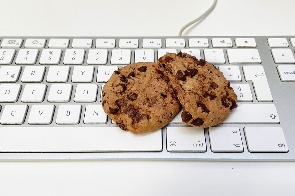 sulla tastiera di un pc sono appoggiati due biscotti cookie