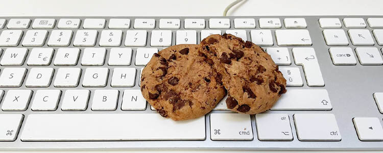 sulla tastiera di un pc sono appoggiati due biscotti cookie