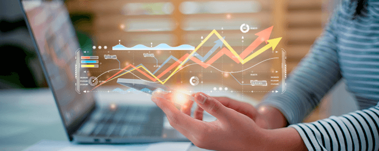 pc sullo sfondo, telefono sulle mani con disegni di grafici sopra
