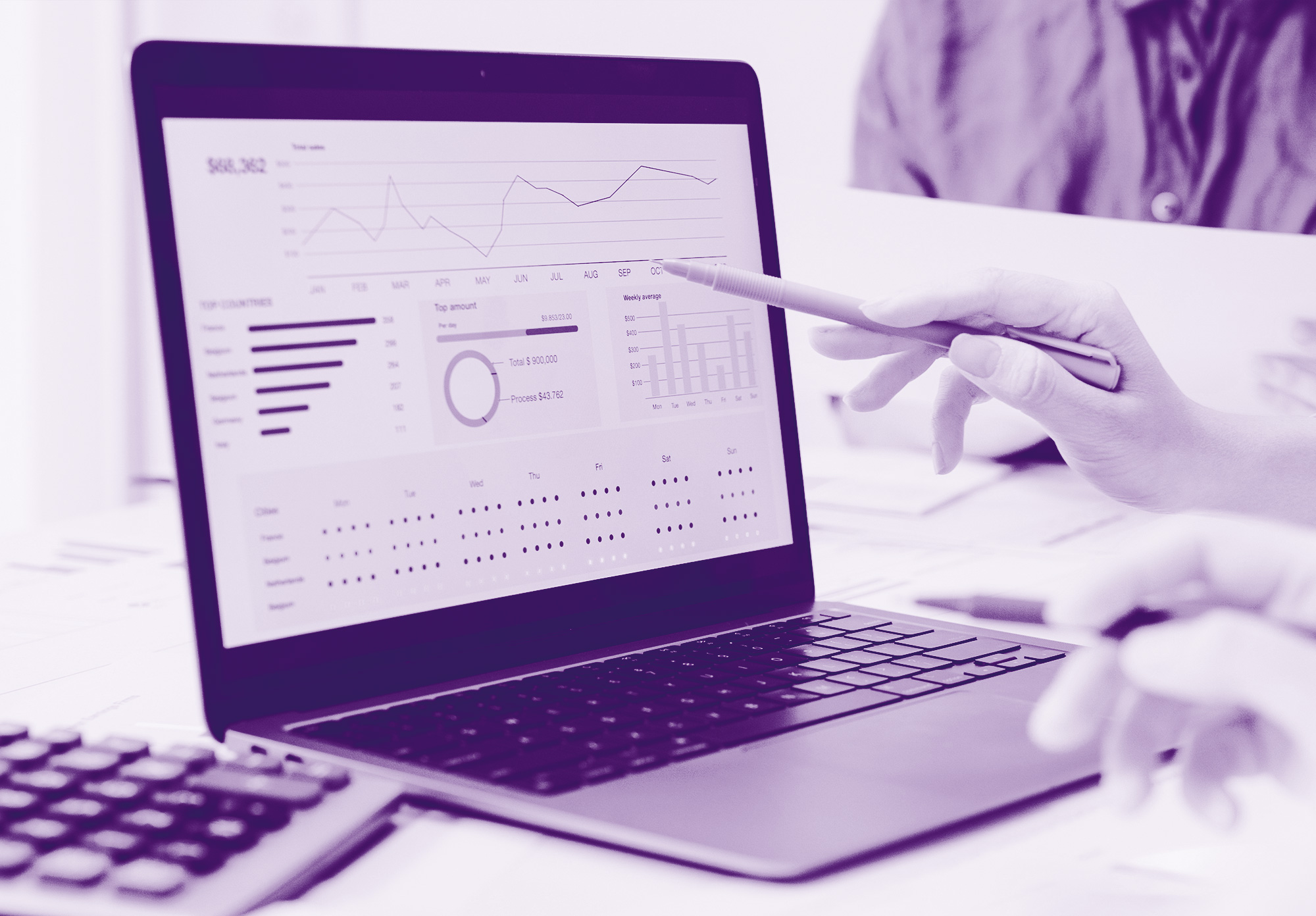 immagine sfondo viola chiaro con un pc dove vengono rappresentati dei grafici della Business Intelligence e una mano con una penna che indica sul monitor del pc