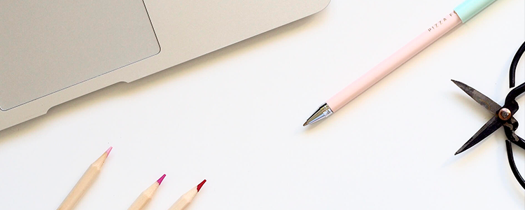 su una scrivania c'è un pezzo di pc e matite colorate