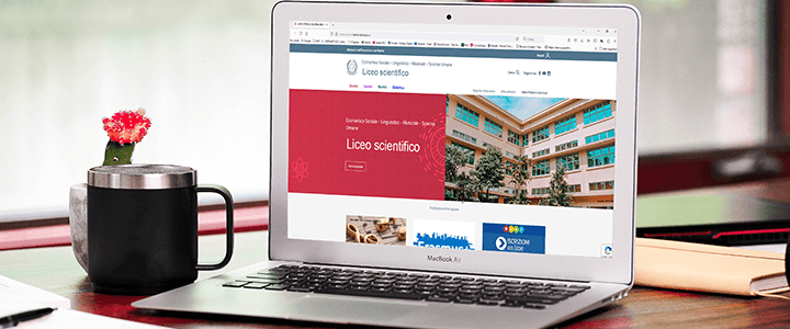 mockup ambientato con pc e sullo sfondo il sito di un liceo scientifico